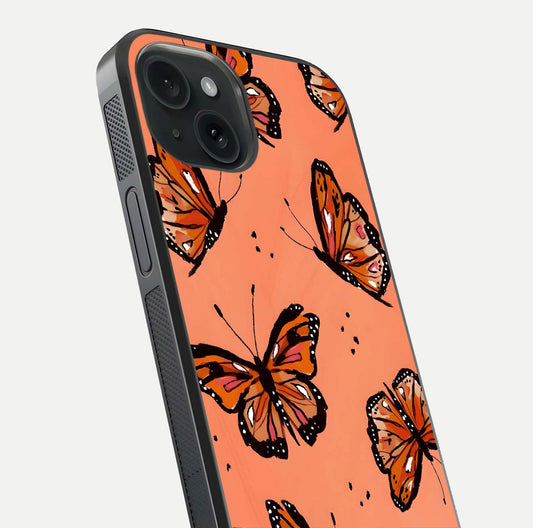 Coral Wing Butterfly Glass Case for iPhone 15 close-up highlighting wing pattern, coral tones, and reflection shine