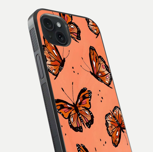 Coral Wing Butterfly Glass Case for iPhone 15 Plus close-up highlighting wing pattern, coral tones, and reflection shine