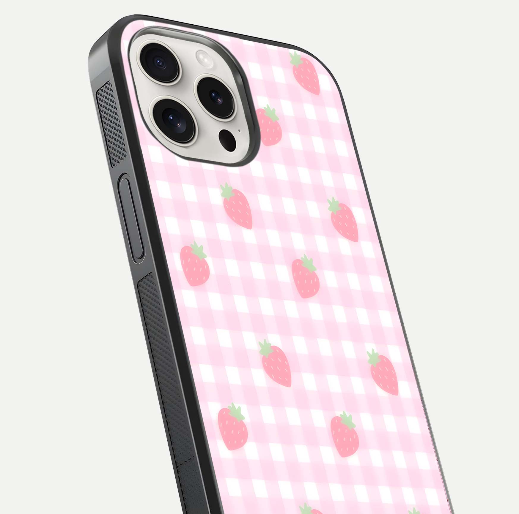 Strawberry Picnic Love iPhone 15 Pro Max glass phone case angled back view highlighting strawberry illustrations and textured grip