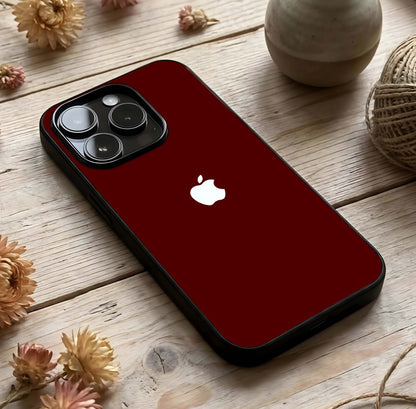 Apple Crimson Core Glass Case photographed in natural light showing reflective finish and deep color dimension.