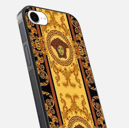 Golden Royal Heritage Glass Case for iPhone 16e close-up angled shot showing intricate design and metallic reflection