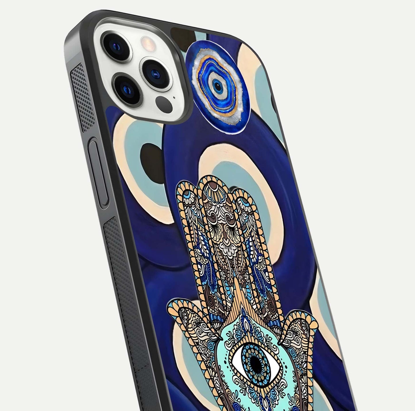 Hamsa Divine Guard Glass Case for iPhone 12 Pro close-up angled shot showing detailed palm motif and reflection glow