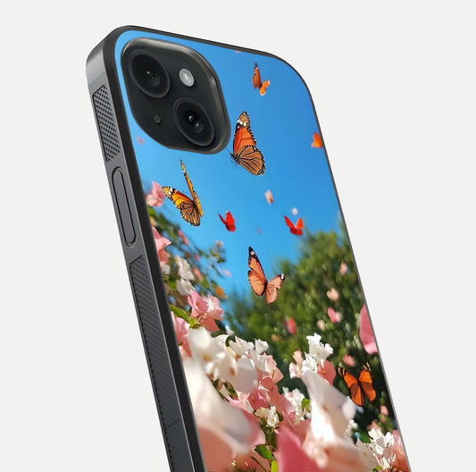 Butterflies in Bloom Sky Glass Case for iPhone 15 close-up shot showing wings, petal reflections, and soft hues